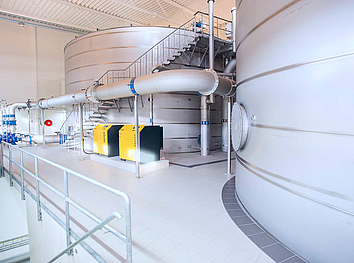 Industrial UV disinfection systems made of stainless steel with electrical control boxes in a production environment.